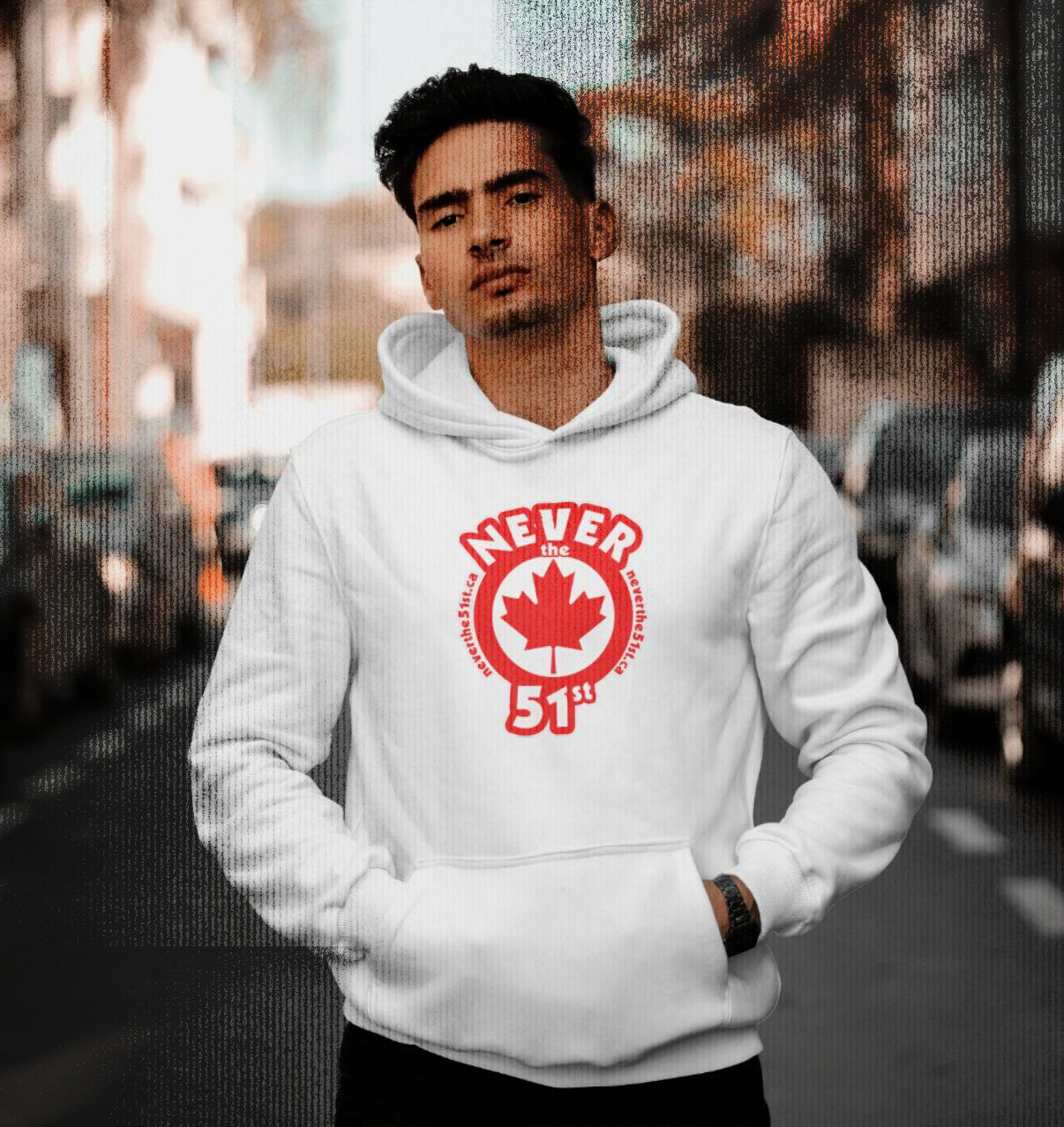 Man wearing a white Never the 51st hoodie with red maple leaf logo, standing confidently on a Montreal street